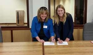 Lisa Coverdale, NRCS state conservationist for Montana, and Elena Evans, executive director for the Soil and Water Conservation Districts of Montana, Inc., sign an agreement to add another SGI Strategic Watershed Action Team position in Ekalaka, Montana.